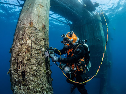 Professional diver inspecting underwater structure